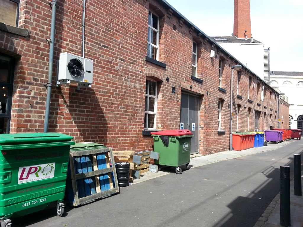 Red brick, air con units and recycling bins