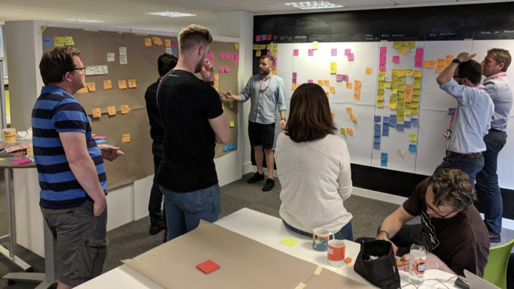People looking at sticky notes on two walls